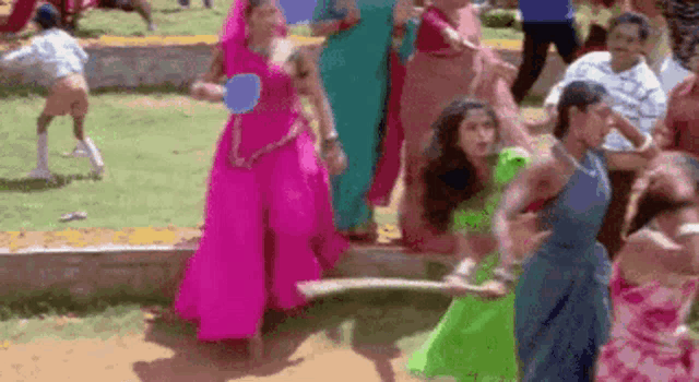 a group of women are dancing in a park with balloons in their hands .