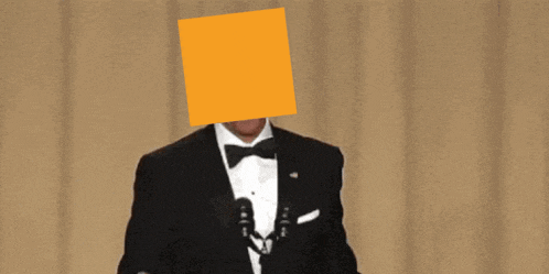 a man in a tuxedo has a yellow square on his face