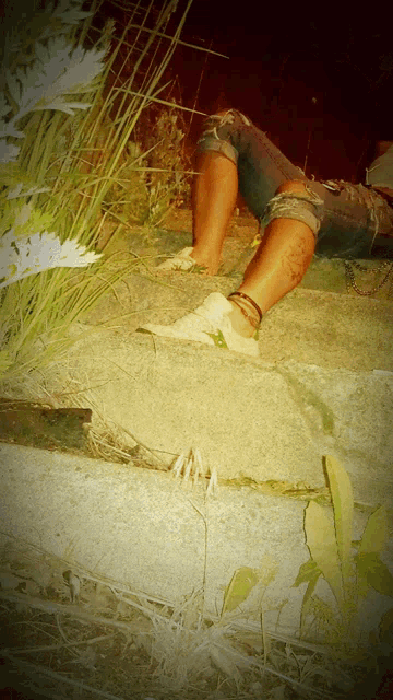 a person laying on a concrete surface with their feet in the grass