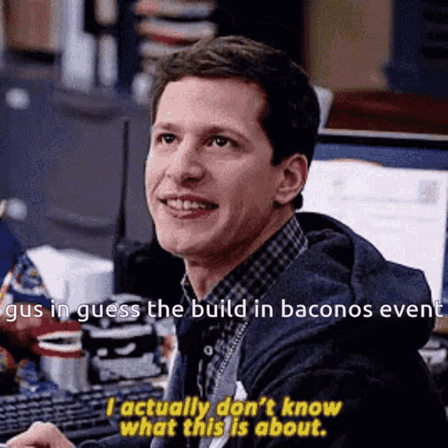 a man is sitting at a desk with a computer and says gus in guess the build in baconos event .