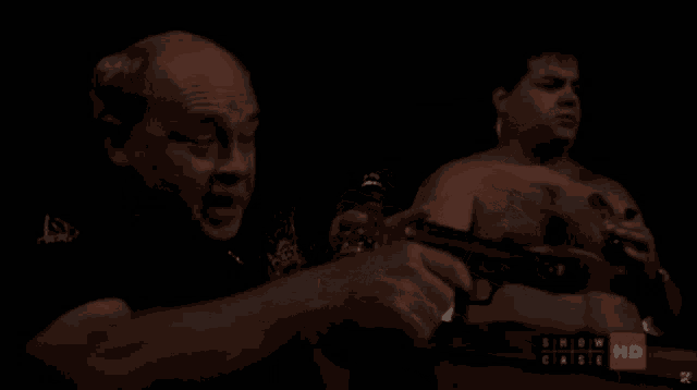 a group of men are standing in a dark room with the words show case on the bottom left