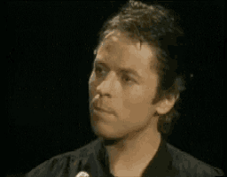 a close up of a man 's face in a black shirt .