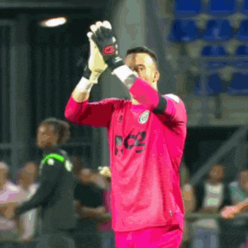 a soccer player wearing a pink jersey with the letters rc2 on it