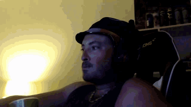 a man wearing headphones and a hat is sitting in a cing chair