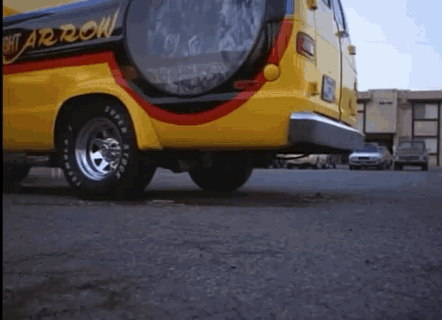 a yellow arrow van is parked on the side of the road