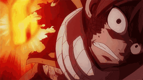 a close up of a person 's face with a fire behind them .