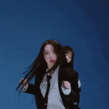 a woman wearing a suit and tie is dancing