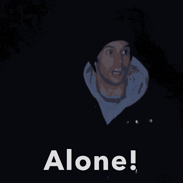 a man is standing in the dark with the word alone written below him