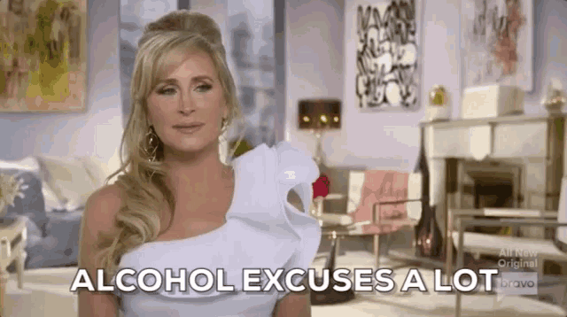 a woman in a white dress says alcohol excuses a lot in a living room