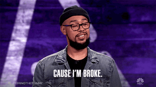 a man wearing glasses and a beanie says cause i 'm broke