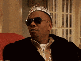 a man wearing a crown and sunglasses looks to the side