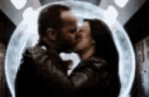 a man and a woman are kissing in front of a glass globe .