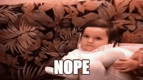 a baby is sitting on a couch and making a funny face while being held by a woman .