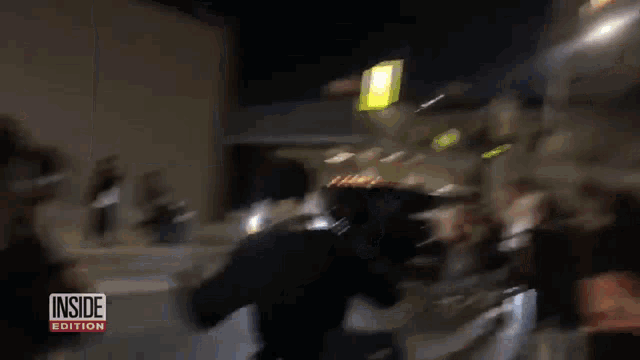 a blurry picture of a group of people with the words inside edition on the bottom right