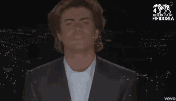 a man in a suit and white shirt is dancing with the words mengache pa aca behind him