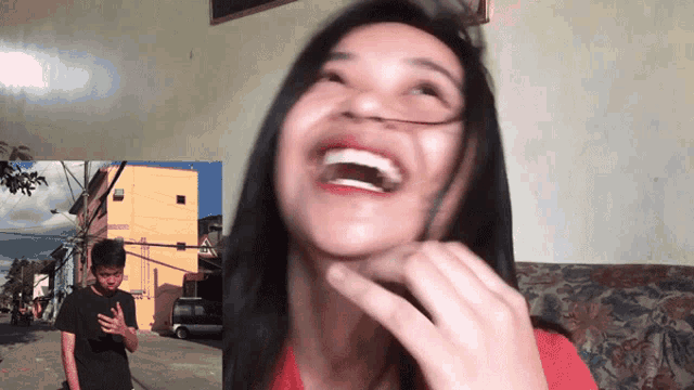 a man and a woman are laughing in front of a building that says ' a ' on it