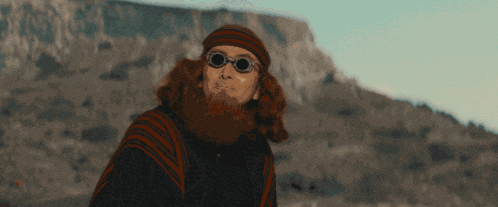 a man with a beard wearing sunglasses and a beanie