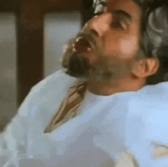 a man is laying in a hospital bed with his mouth open .