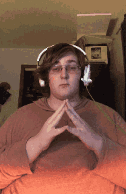 a man wearing headphones and glasses is making a heart shape with his hands