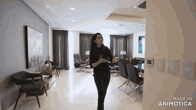 a woman is standing in a living room with the words made in animatica on the bottom
