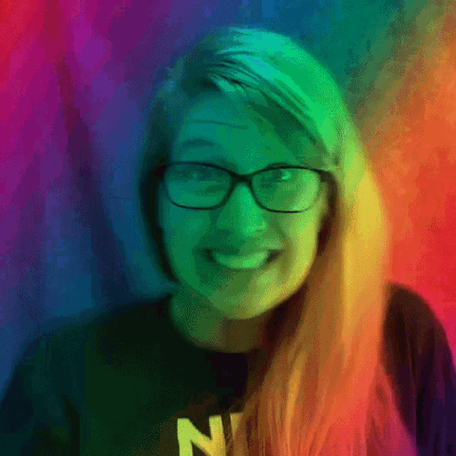 a woman wearing glasses and a black shirt with the letter n on it is smiling