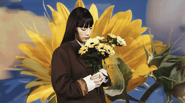 a woman holding a bouquet of flowers in front of a large sunflower