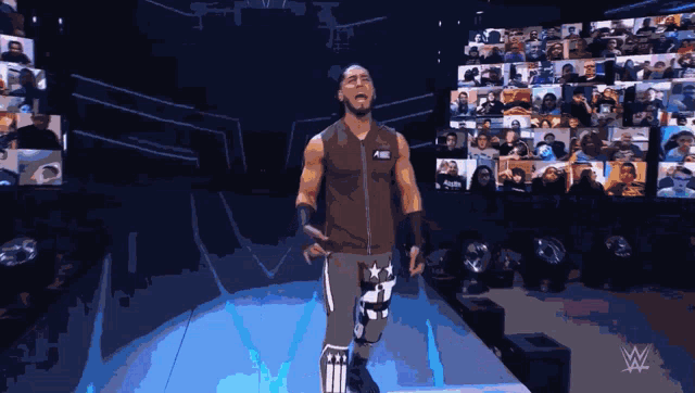 a wrestler is standing on a stage in front of a crowd with a w logo in the corner