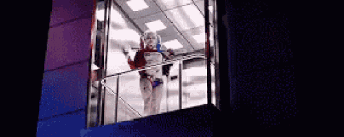 harley quinn is standing on the balcony of a building .