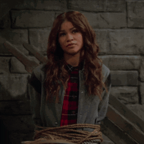 a woman in a plaid shirt and a denim jacket is tied up