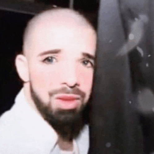 a close up of a man with a beard and bald head .