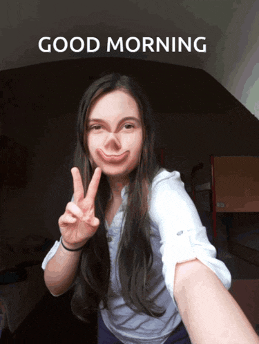 a woman giving a peace sign with the words good morning behind her
