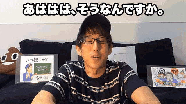 a man sitting on a couch with a sign in front of him that says ' nishiman show '