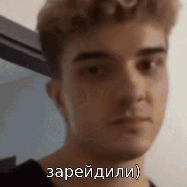 a close up of a man 's face with the words " зарядили " written on it