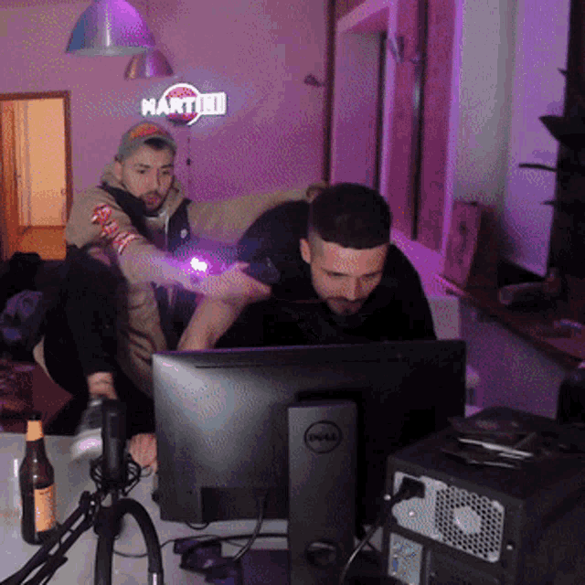two men are sitting in front of a dell computer monitor