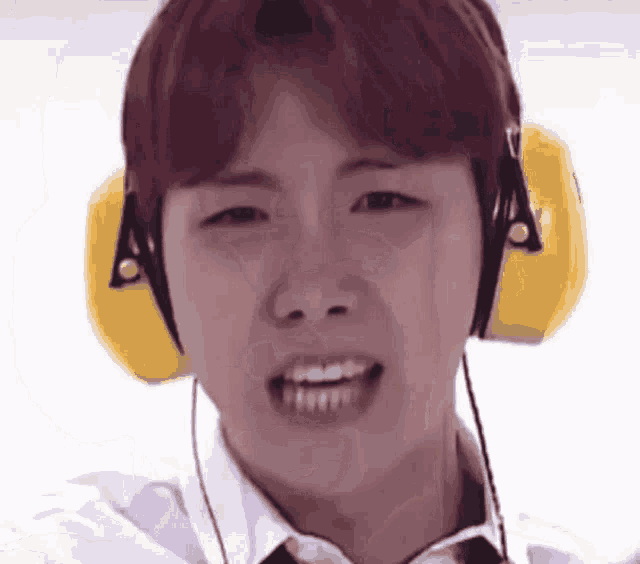 a close up of a person wearing headphones and smiling .
