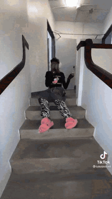 a woman is sitting on a set of stairs holding a glass of wine .