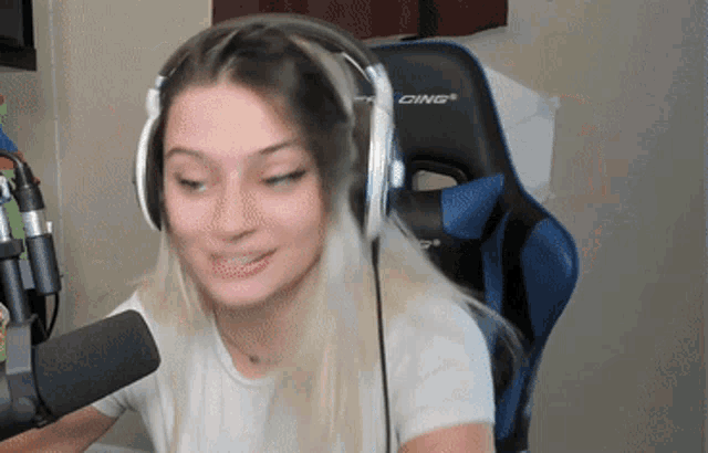 a woman wearing headphones is sitting in a chair that says racing