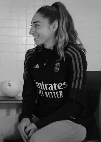 a black and white photo of a woman wearing an adidas shirt that says emirates fly better