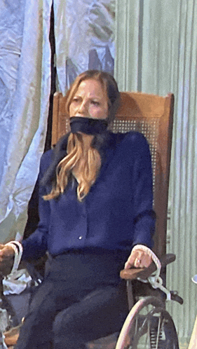 a woman sitting in a chair with her mouth taped