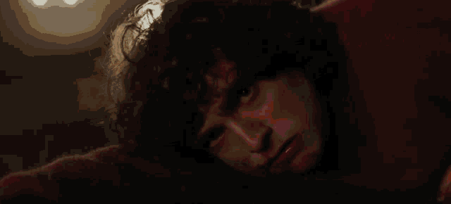a close up of a person 's face with a glowing light behind them