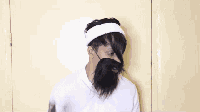 a man with a beard and a headband is holding a pair of scissors