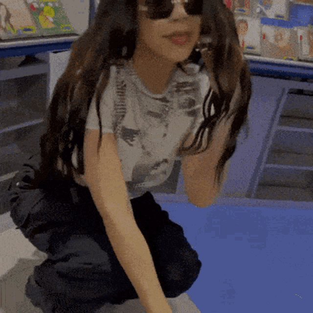 a girl wearing sunglasses and a t-shirt with a picture of a cat on it