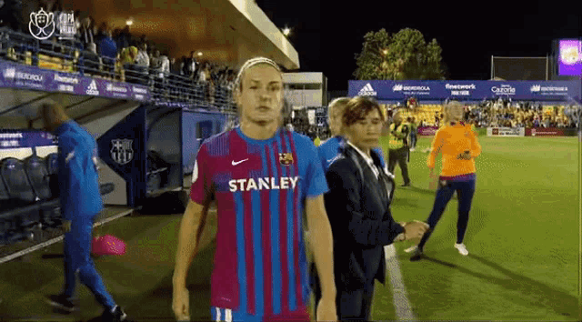a female soccer player wearing a stanley jersey walks off the field