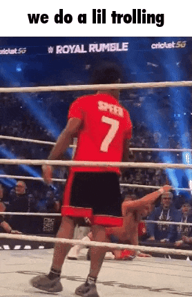a man wearing a red shirt with the number 7 on it is standing in a boxing ring .