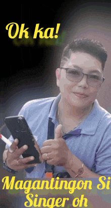 a man wearing glasses is holding a cellphone and giving a thumbs up
