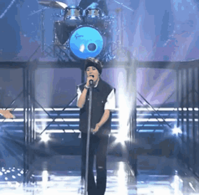 a man singing into a microphone on a stage