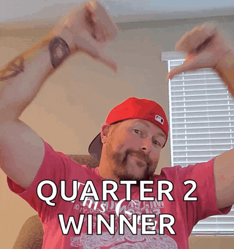 a man wearing a red hat and a pink shirt that says quarter 2 winner on it