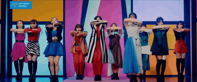 a group of girls are dancing in front of a sign that says up front works