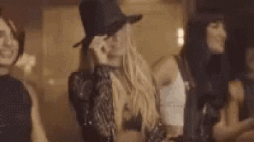 a woman in a hat is standing next to another woman in a room .