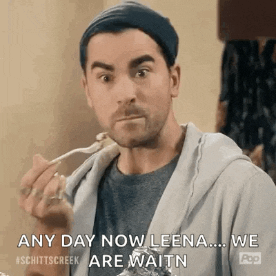 a man is eating food with a fork and spoon and says `` any day now leena ... we are waitn '' .